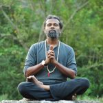 meditative man practicing yoga outdoors