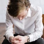 woman in white dress shirt and blue denim jeans sitting on chair