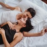 happy couple lying and laughing in bed