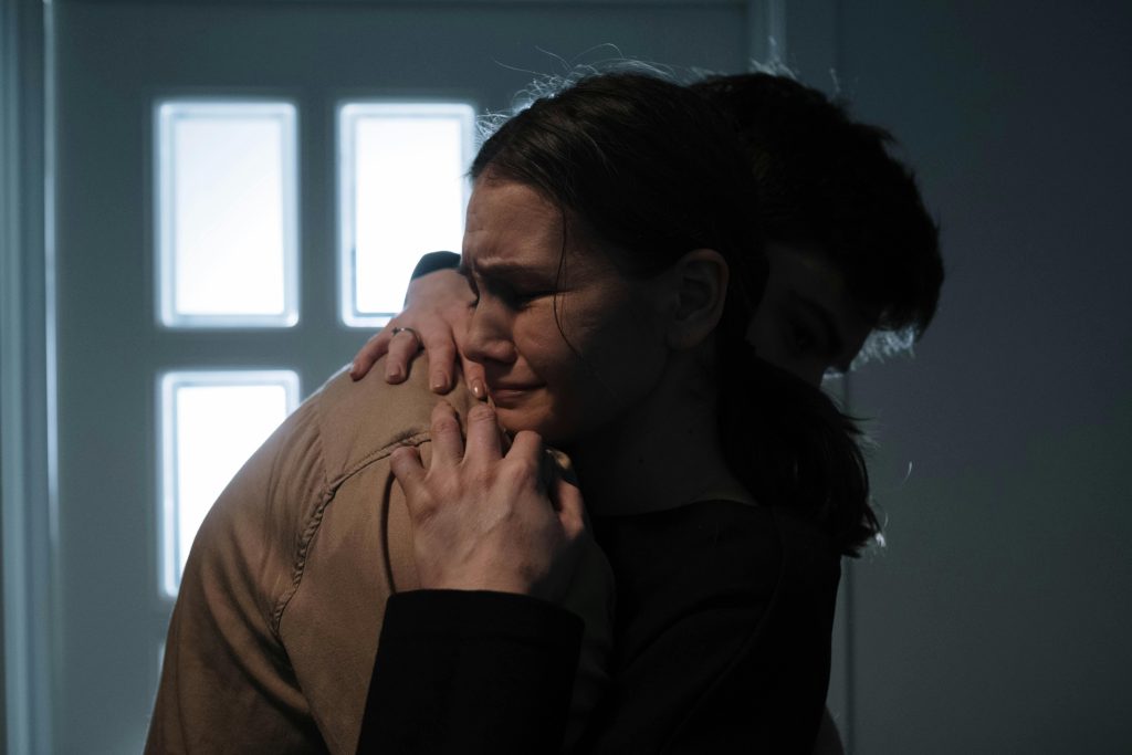 A comforting embrace between two people expressing vulnerability and support.
