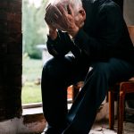 man sitting on brown woden chair
